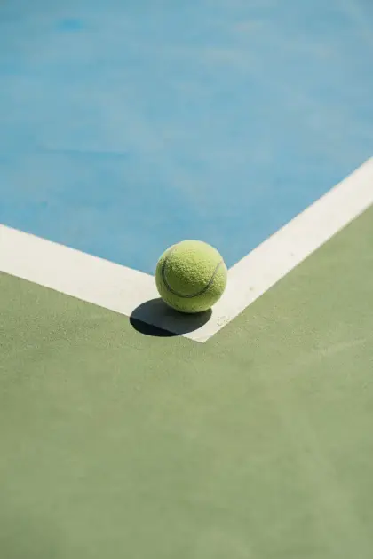 Echtes Foto eines Tennisballs mit seinem Schatten über den Platzlinien